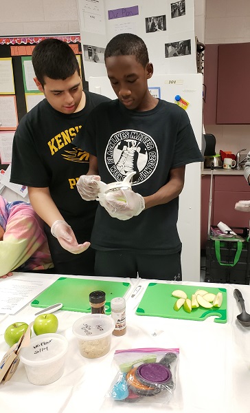 Male high school students cutting up apples in EAT RIGHT PHILLY nutrition class.